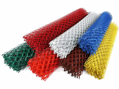 Seven rolls of Polyvinyl chloride chain link fabric in red, orange, brown, yellow, blue, green, and white colors.