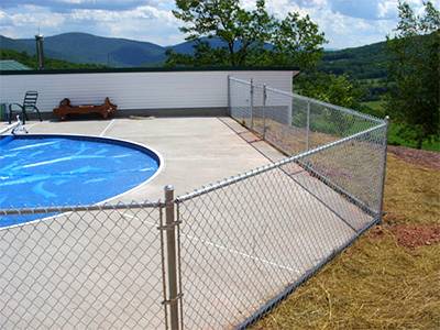 Aluminum coated chain link mesh pool fence under the blue sky, and the blue water in the swimming pool is clear and transparent.