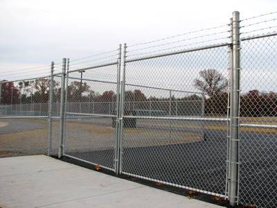 A zinc alloy coated chain link double swing gates with three rows of barbed wire on top.