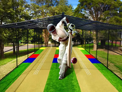 A white dressed man is playing cricket in a black cricket enclosure.