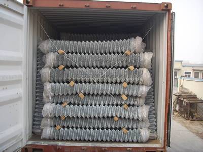 A container is loaded with galvanized chain link meshes.