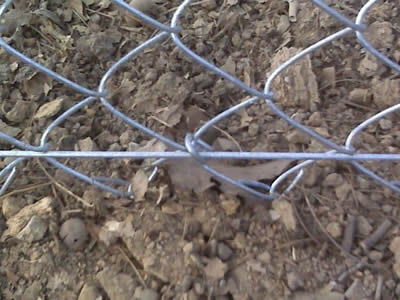 A tension bar is installed at the bottom of chain link fence.
