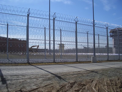 Chain link fences with razor wires surrounding the prison.