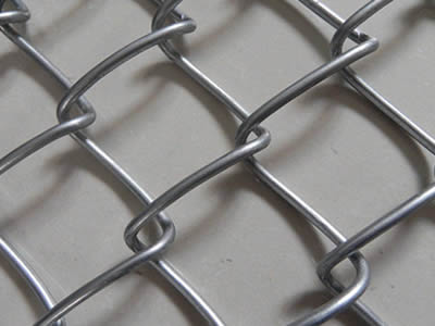 A part of a galvanized chain link wire mesh, four unabridged opening meshes are showed in the middle.