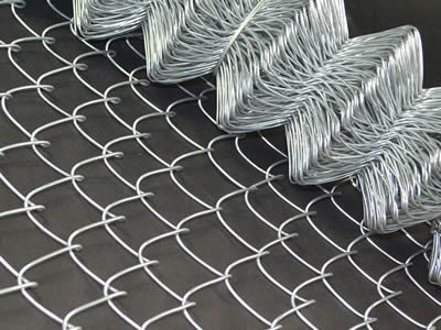 A roll of galvanized chain link fencing with part opened.