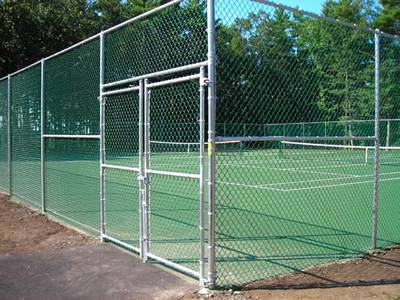 Green polymer-coated chain link fabric tennis courts fencing with double chain link gates.