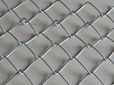 A piece of galvanized chain link mesh on the ground.