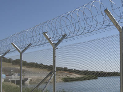 Concertina razor barbed wire is installed on  the top of chain link fence for river fencing.