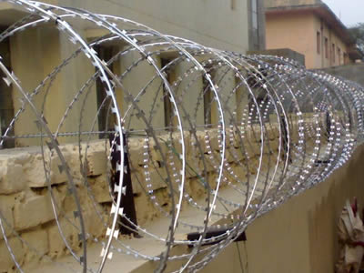 A line of concertina razor wire is installed on the wall.